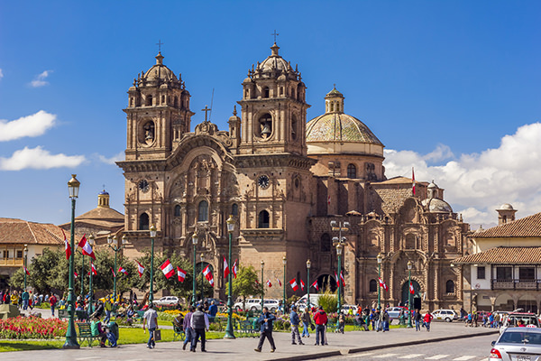 Cuzco, Peru - July 16, 2013: tourists at the Plaza de Armas and Society of Jesus church