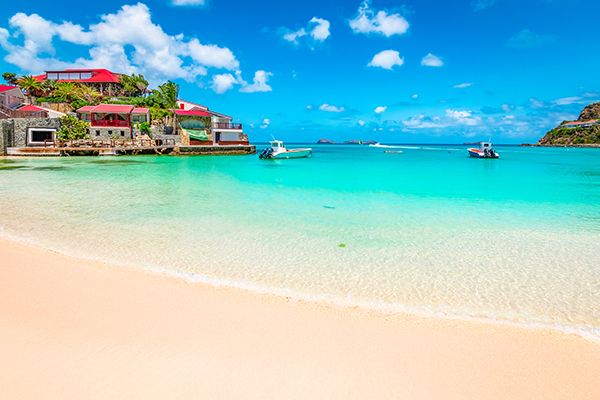 Beautiful idyllic beach with white sand, turquoise sea and blue sky. Luxury summer vacation destination in Saint Barthelemy, the Caribbean.