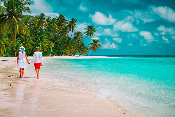 casal amoroso feliz caminhando em férias em uma praia tropical