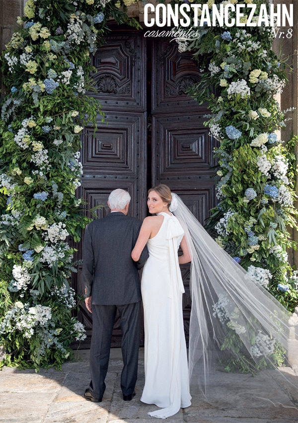 tendências de decoração de casamentos 2022, noiva na porta da igreja, arco de flores azuis e brancas