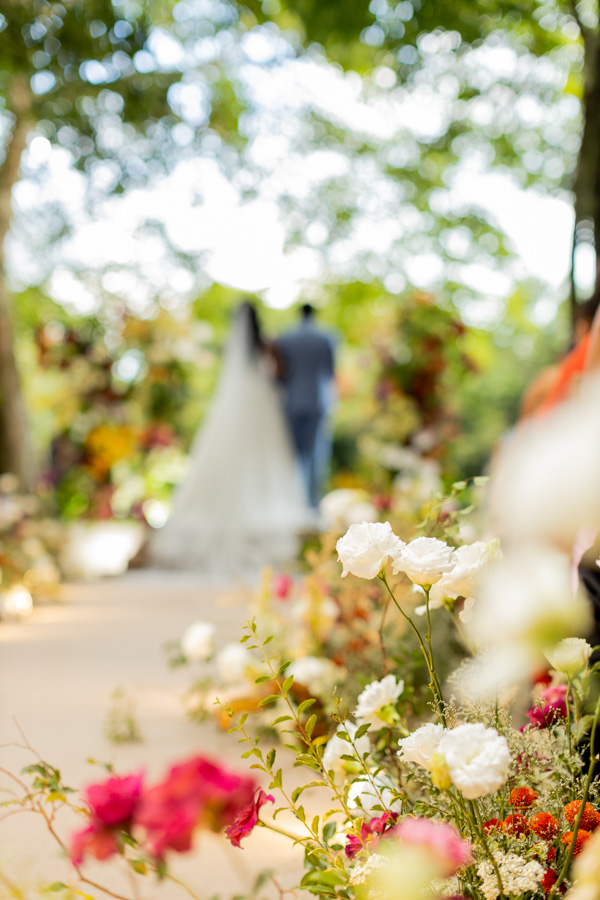 Casamento de Camilla de Lucas e Mateus Ricardo no Rio de Janeiro, foto embaçada com destaque para as flores brancas e rosas do caminho 