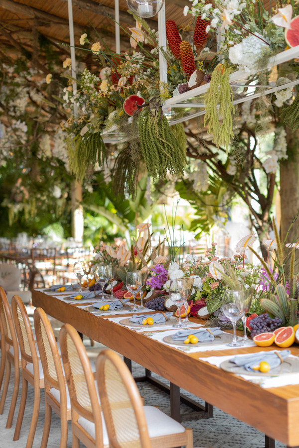 Casamento de Camilla de Lucas e Mateus Ricardo, decoração tropical, mesa decorada com frutas e folhagens, mesa e cadeiras de madeira clara 