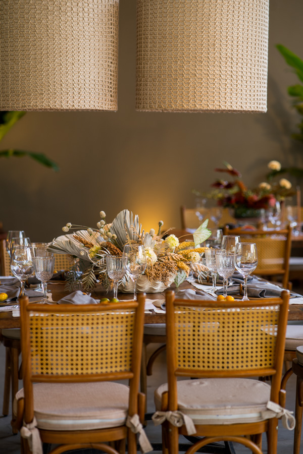 Casamento de Camilla de Lucas e Mateus Ricardo, decoração da mesa dos convidados, lustres em tons de marrom claro, buquê de flores em cima da mesa