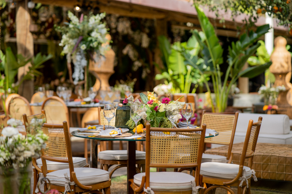 Casamento de Camilla de Lucas e Mateus Ricardo, decoração tropical com foco em folhagens, flores e frutas, mesa dos convidados em formato redondo, espaço ao ar livre