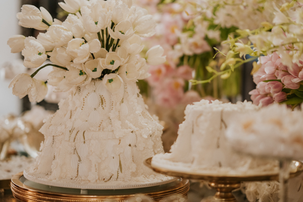 Bolo da mesa de doces do noivado de Paula Aziz e Francisco Garcia, bolo branco com enfeites de tulipa 