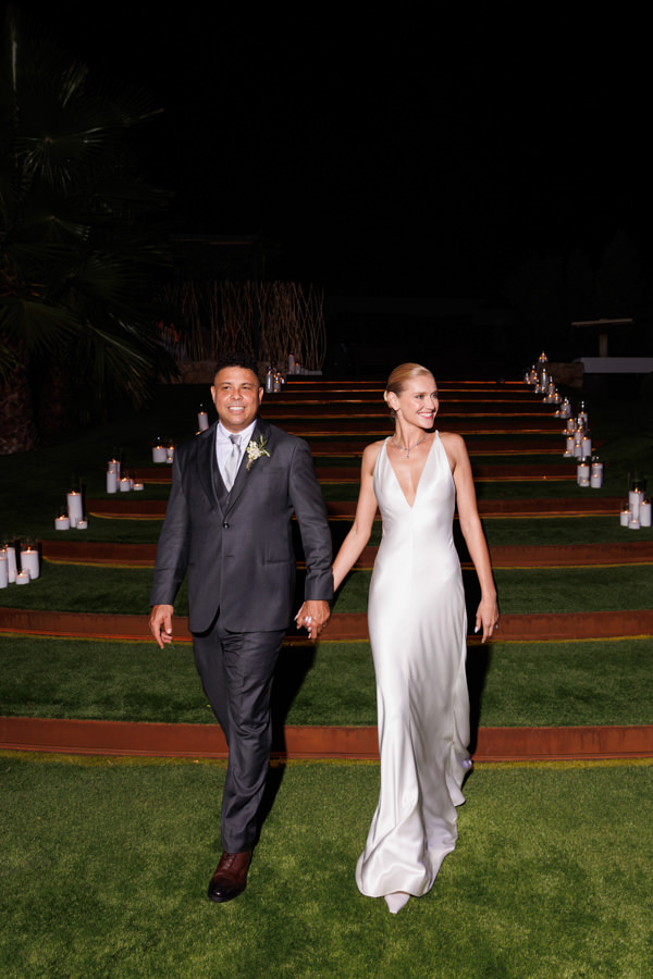 Casamento de Celina Locks e Ronaldo em Ibiza, casamento na Espanha, Ronaldo Nazário, casamento em casa, vestido de noiva, Giorgio Armani Privé, casamento ao ar livre, casamento de tarde, Celina e Ronaldo entrando na festa, ensaio pós wedding, Celina a Ronaldo descendo escadas, escadas com velas, festa de casamento