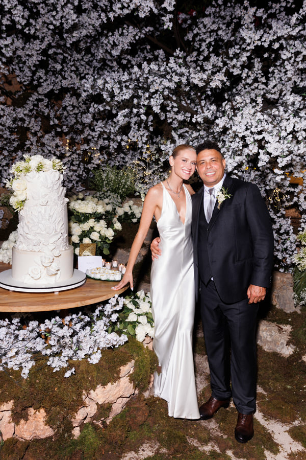 Casamento de Celina Locks e Ronaldo em Ibiza, casamento na Espanha, Ronaldo Nazário, casamento em casa, vestido de noiva, Giorgio Armani Privé, casamento ao ar livre, casamento de tarde, Celina e Ronaldo na mesa do bolo, ensaio pós wedding, festa de casamento, bolo de casamento, bolo de casamento de Celina Locks e Ronaldo, bolo de casamento branco, bolo de casamento com flores,mesa do bolo
