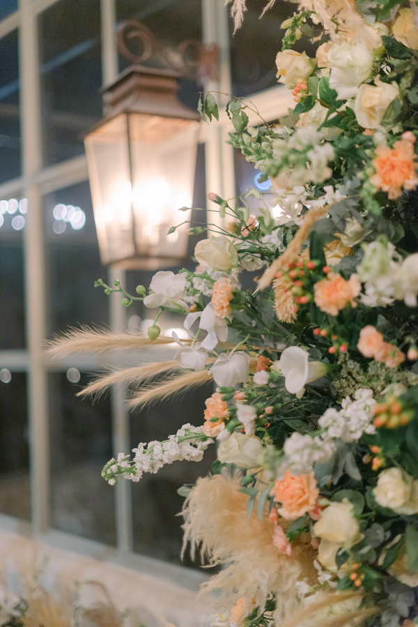Cor Pantone do ano 2024, Peach Fuzz, Decoração de casamento, arranjo floral de casamento, cor pêssego, PANTONE 13-1023 Peach Fuzz, detalhe lateral de arranjo floral, rosas pêssego, flores brancas, trigo seco, lanterna